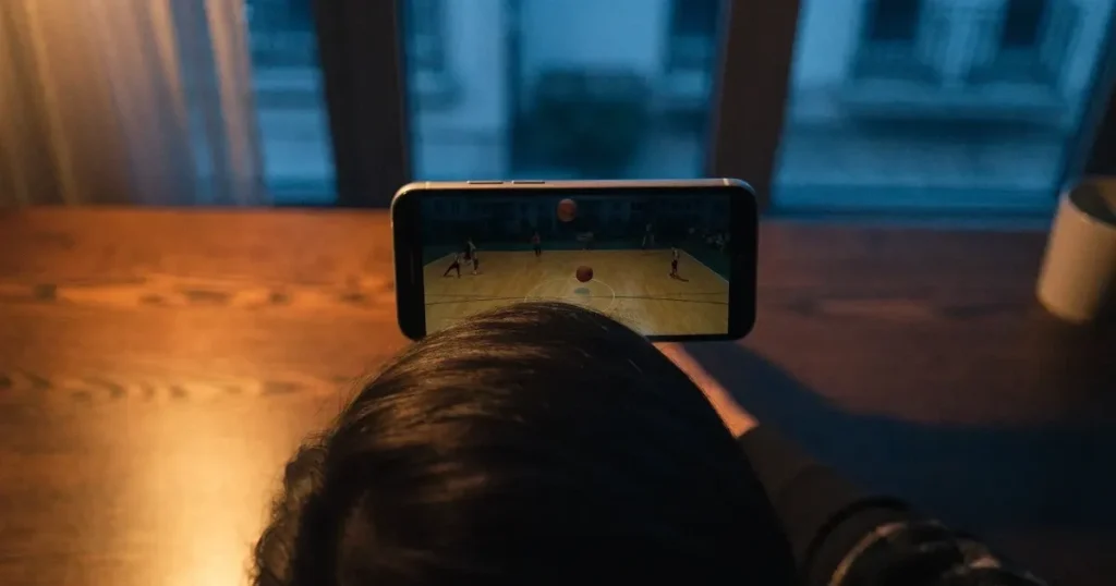 Ein Basketballkorb in einer leeren Halle, der Parkettboden glänzt im Licht der Deckenlampen